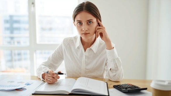 Entrepreneuse tenant une calculatrice illustrant une formation comptabilité pour comprendre les bases de la comptabilité