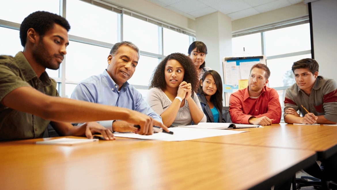 Homme tenant un panneau avec une courbe ascendante pour illustrer la formation de formateur et la progression des compétences