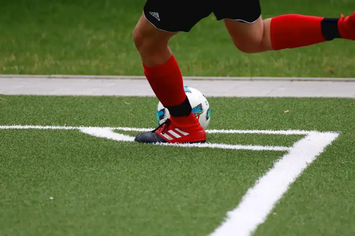 Jeunes filles en tenue de football s'entraînant sur un terrain, ballon en jeu