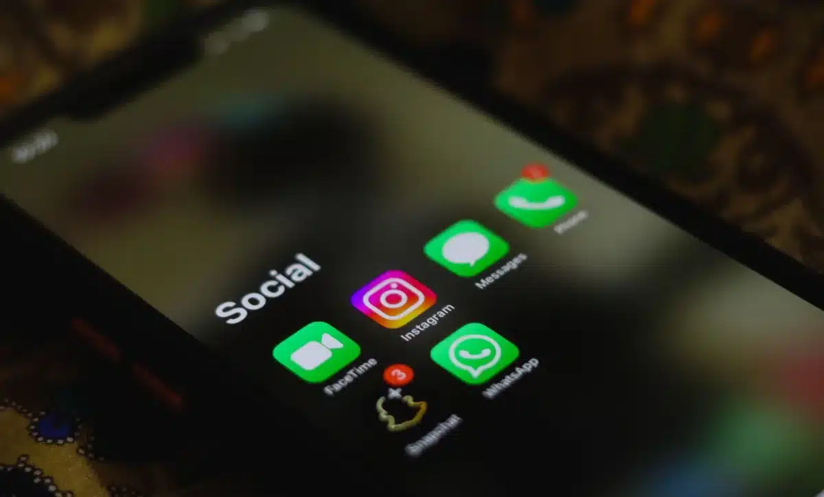 Écran de smartphone montrant une conversation sur les réseaux sociaux avec message menaçant