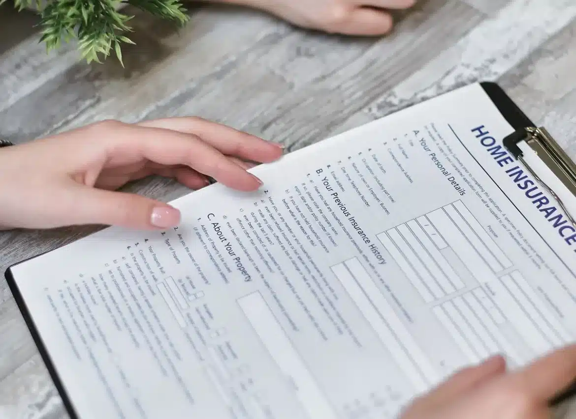 Mains tenant un téléphone affichant des devis d'assurance santé et des graphiques de comparaison