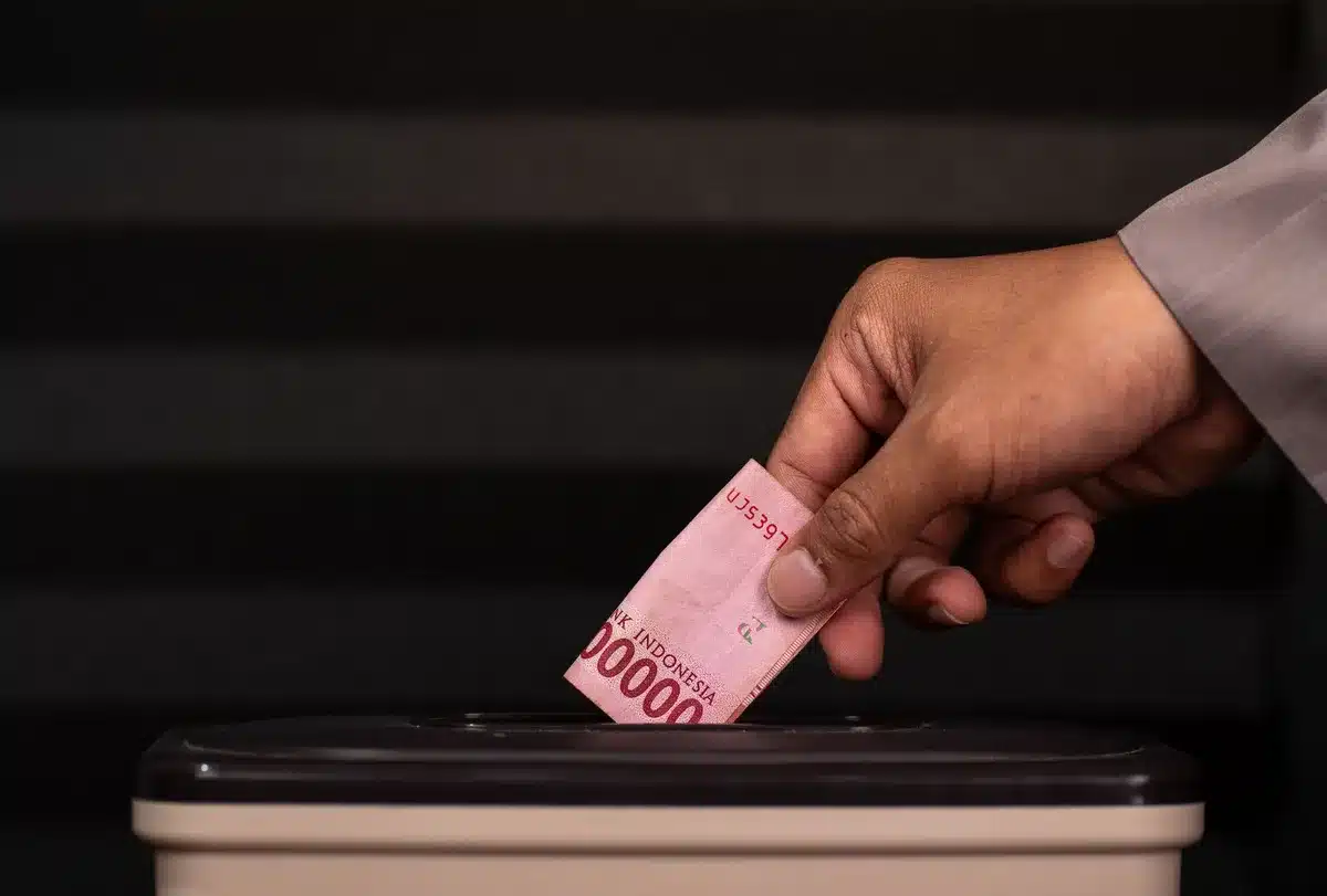 Couple signant un acte de donation devant un notaire dans un bureau