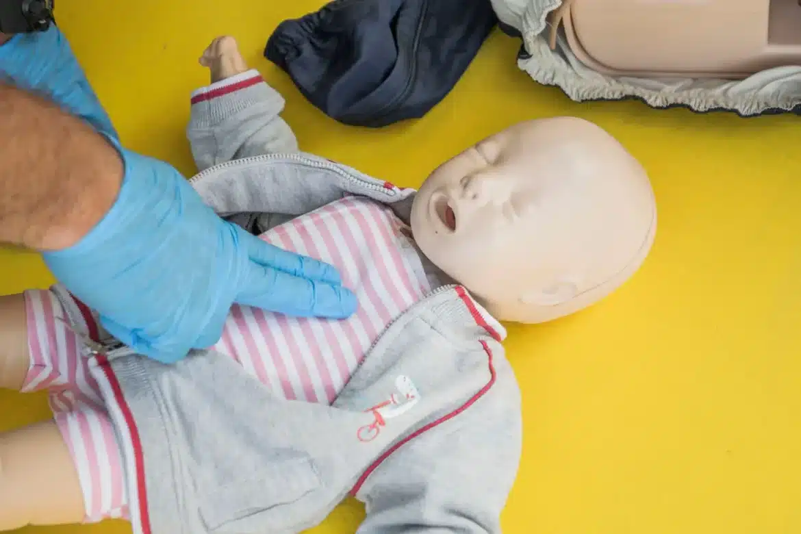Formation aux gestes de réanimation cardio-pulmonaire sur mannequin d'entraînement en salle municipale