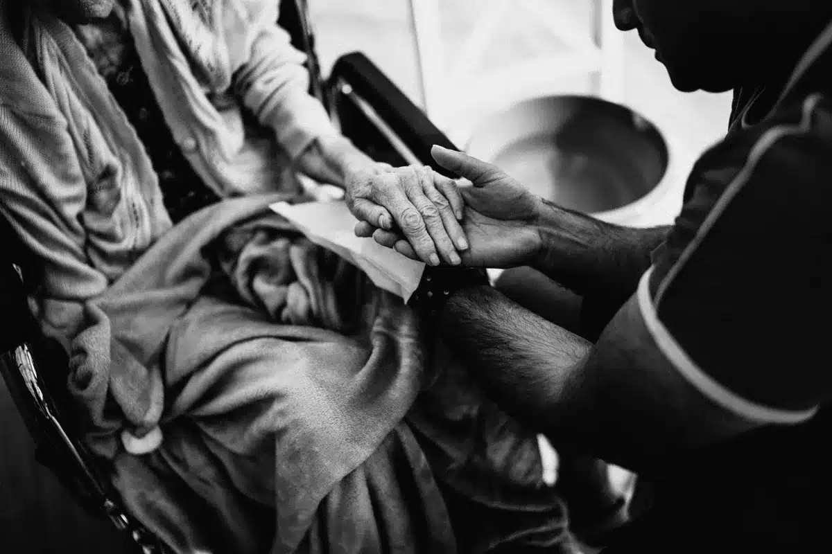 Mains d'une personne aidante, fatiguée, auprès d'une personne âgée.