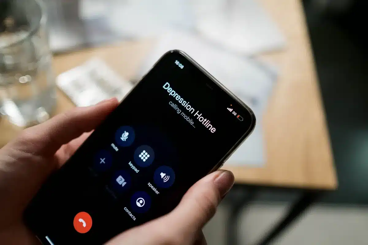 Personne composant un numéro d'urgence sur un téléphone pour demander de l'aide
