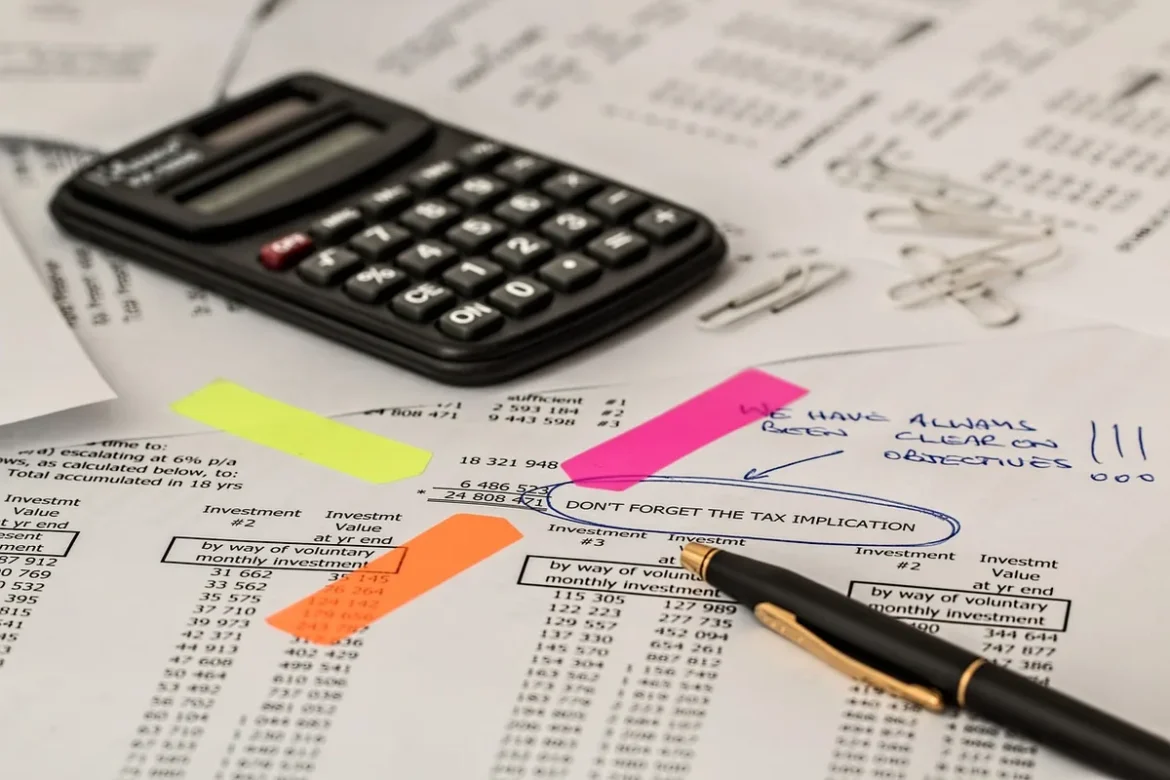 Bureau en journée avec documents financiers et calculatrice près d'une fenêtre
