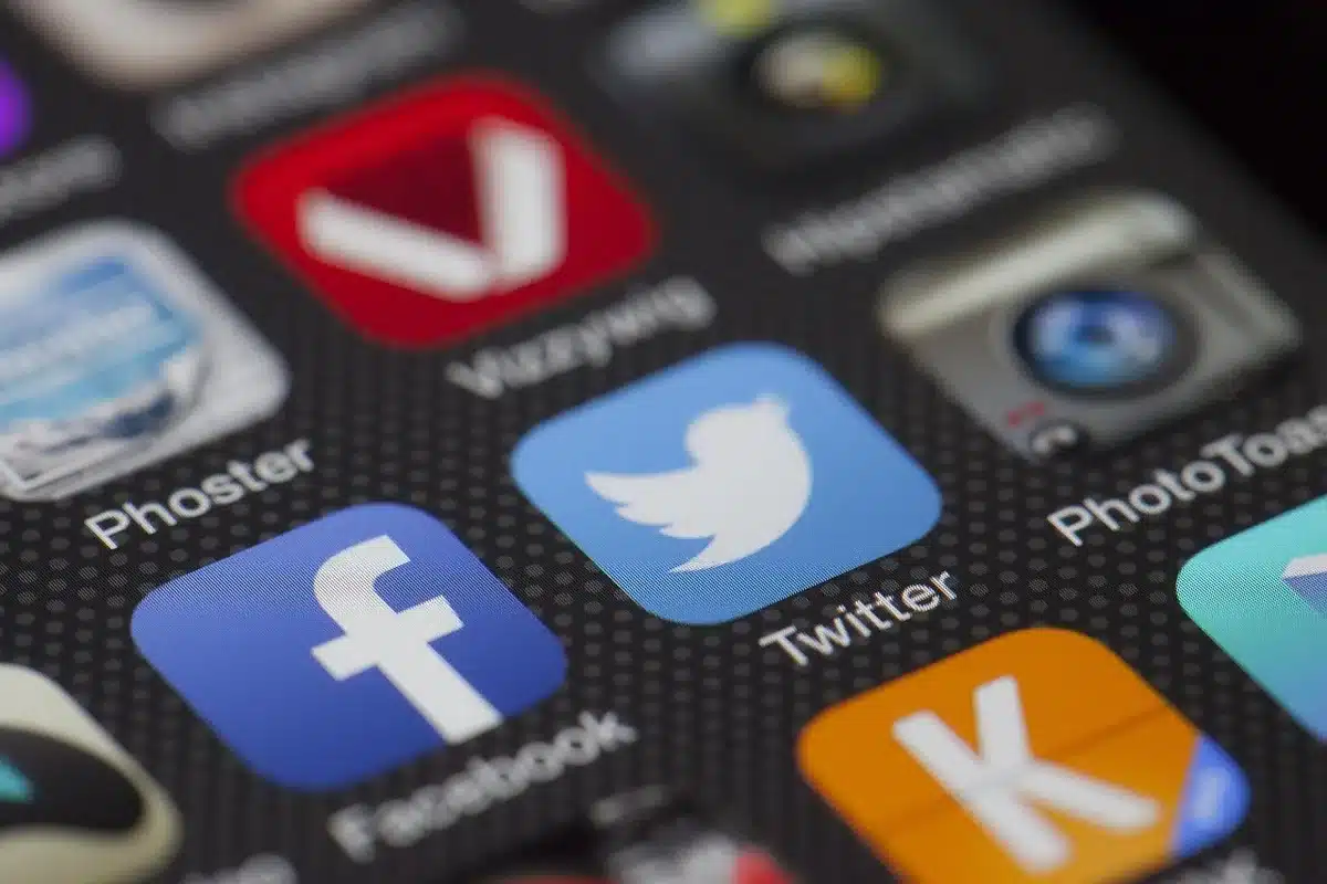 Main tenant un smartphone et capture d'écran d'un post sur les réseaux sociaux