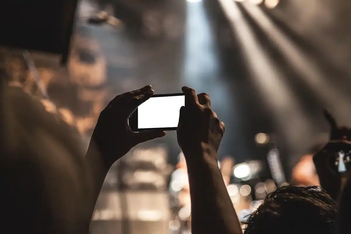 Gros plan d'un pouce faisant défiler un fil d'actualité sur smartphone en journée