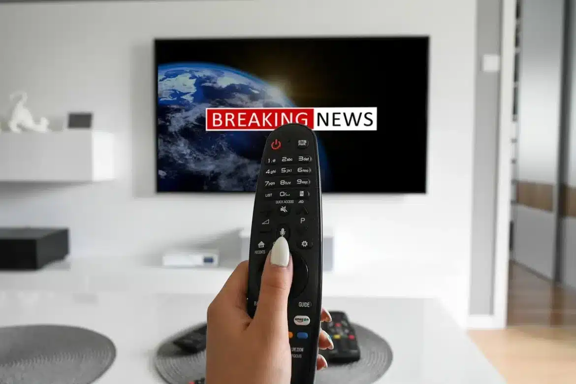 Télécommande et smartphone sur une table basse devant un canapé, lumière du jour