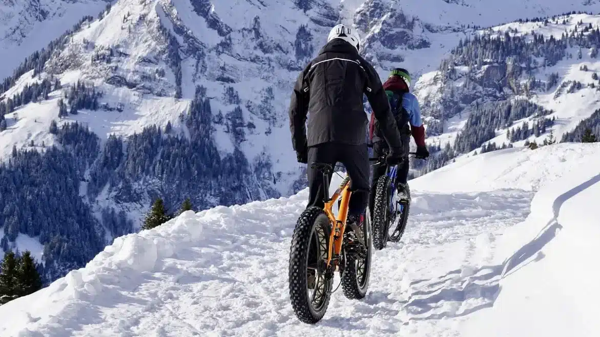 Tente déchirée en montagne enneigée avec des traces de pas dispersées dans la neige