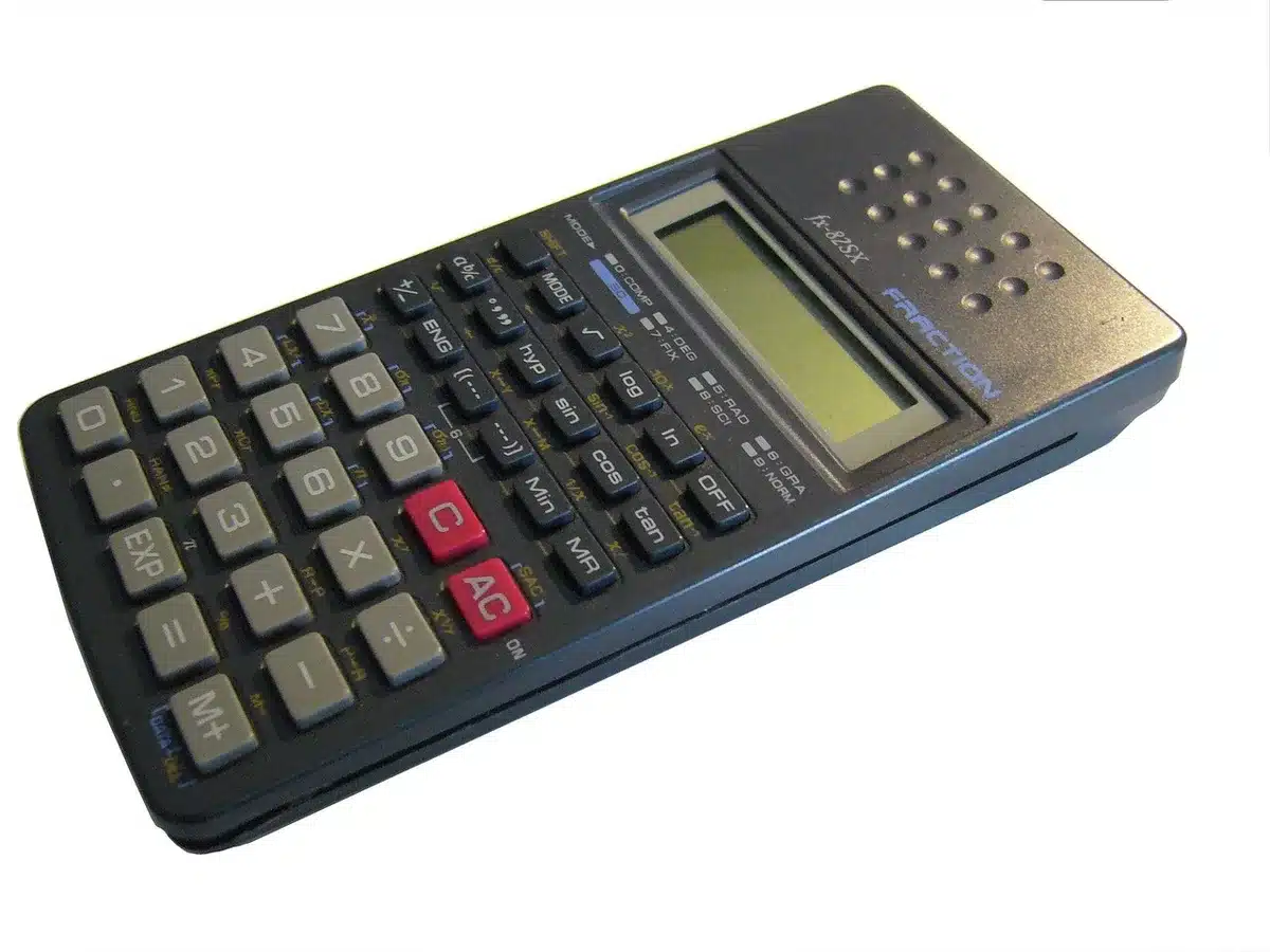 Feuille de calcul de ratios financiers et calculatrice sur un bureau ensoleillé