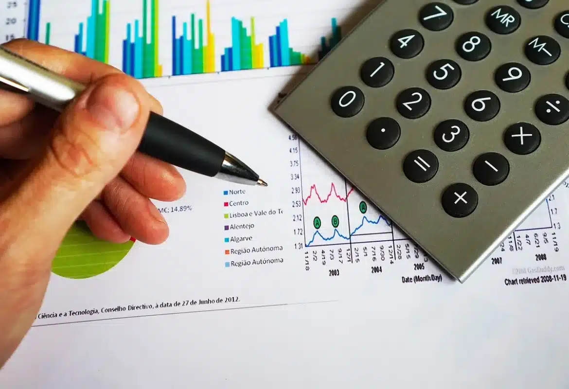 Bureau en plein jour avec rapports financiers et calculatrice sur une table
