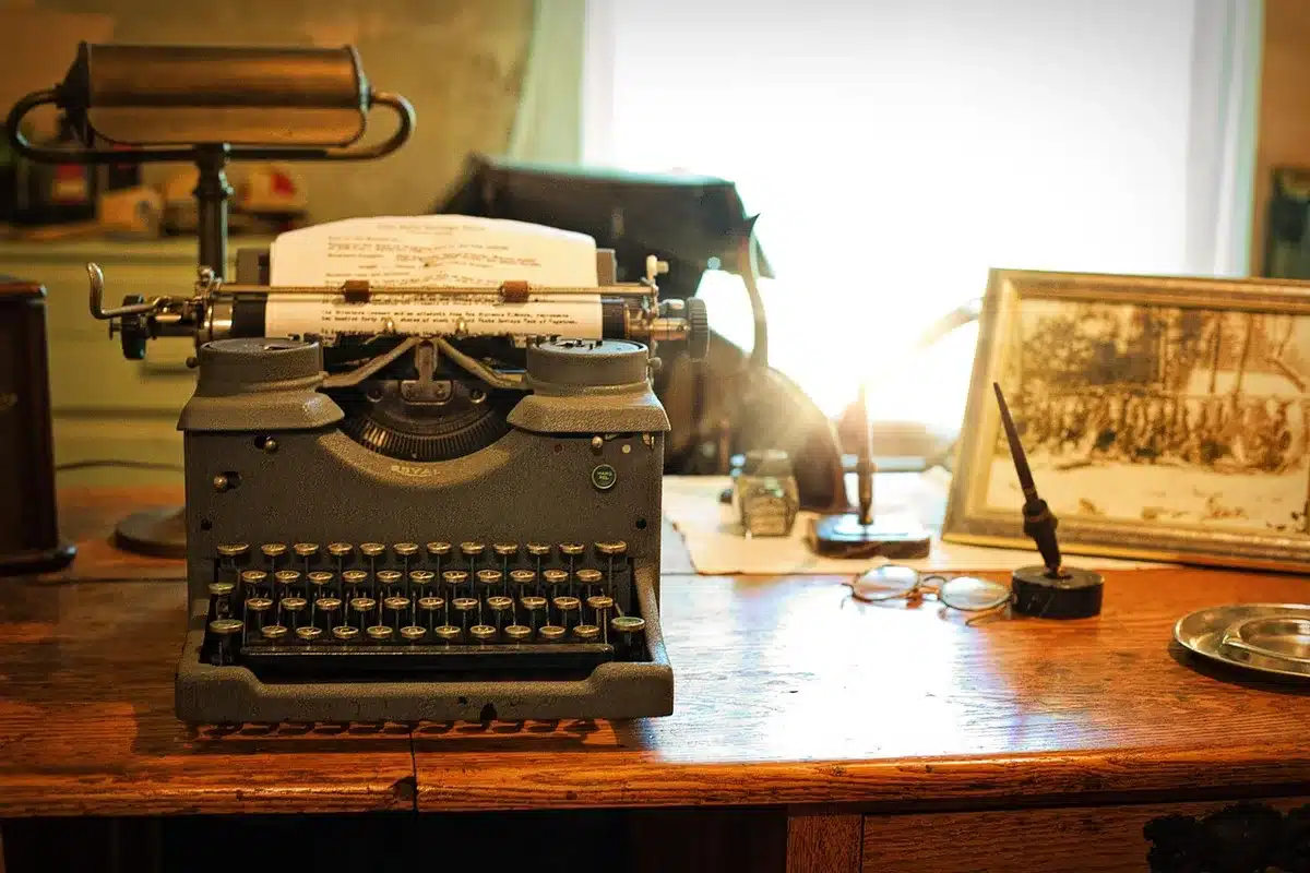 Auteur travaillant sur des archives à une table près d'une fenêtre en journée