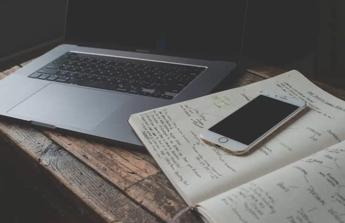 Personne prenant des notes lors d'une recherche de mots-clés sur ordinateur