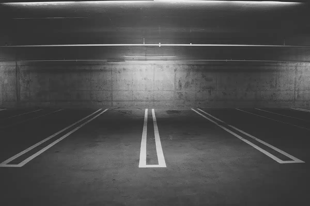 Véhicule couvert d'une bâche sur une aire de parking en journée