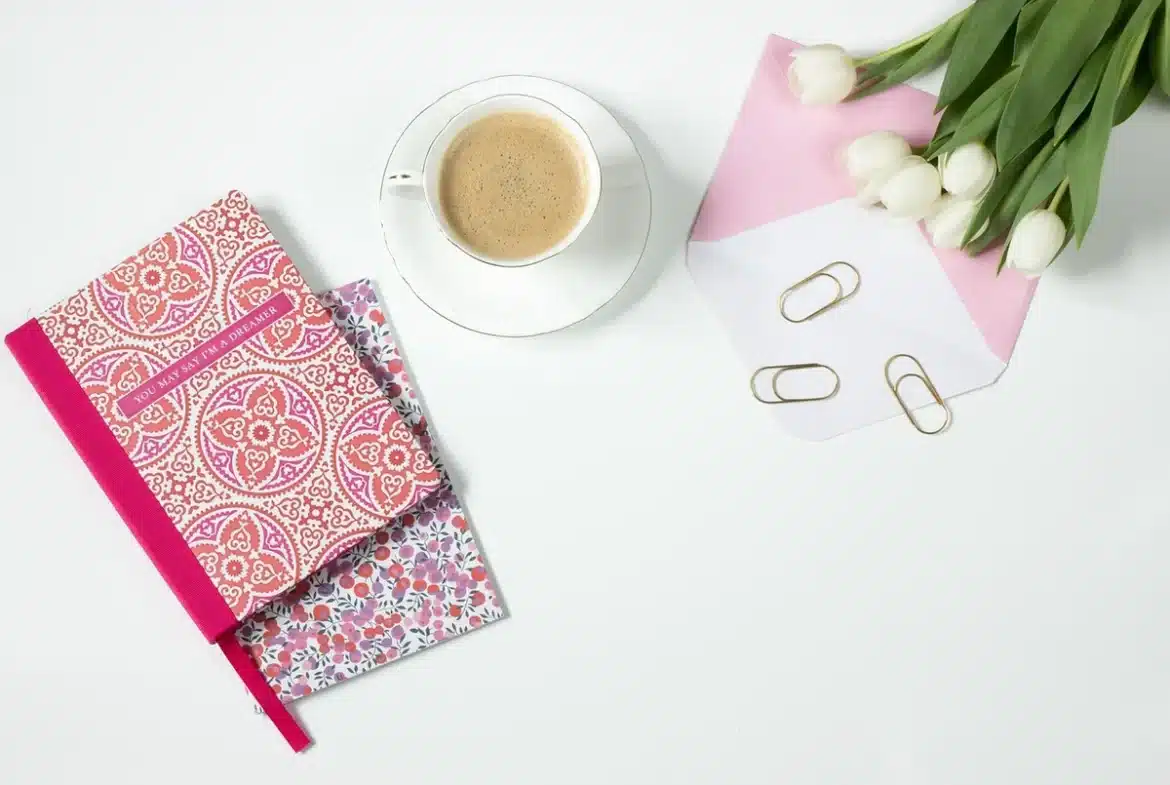 Silhouette anonyme près d'une tasse renversée et d'un carnet, ambiance de bureau détendue