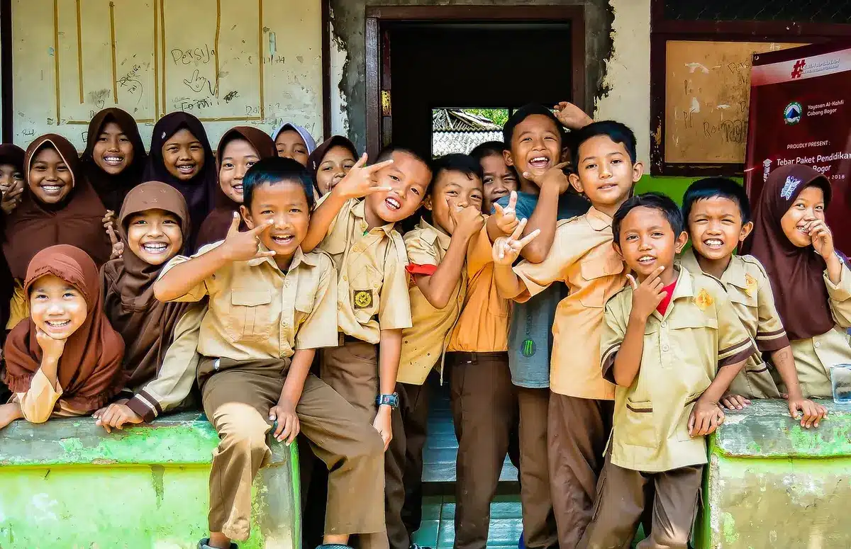File d'enfants à la cantine devant une panneau d'inscription