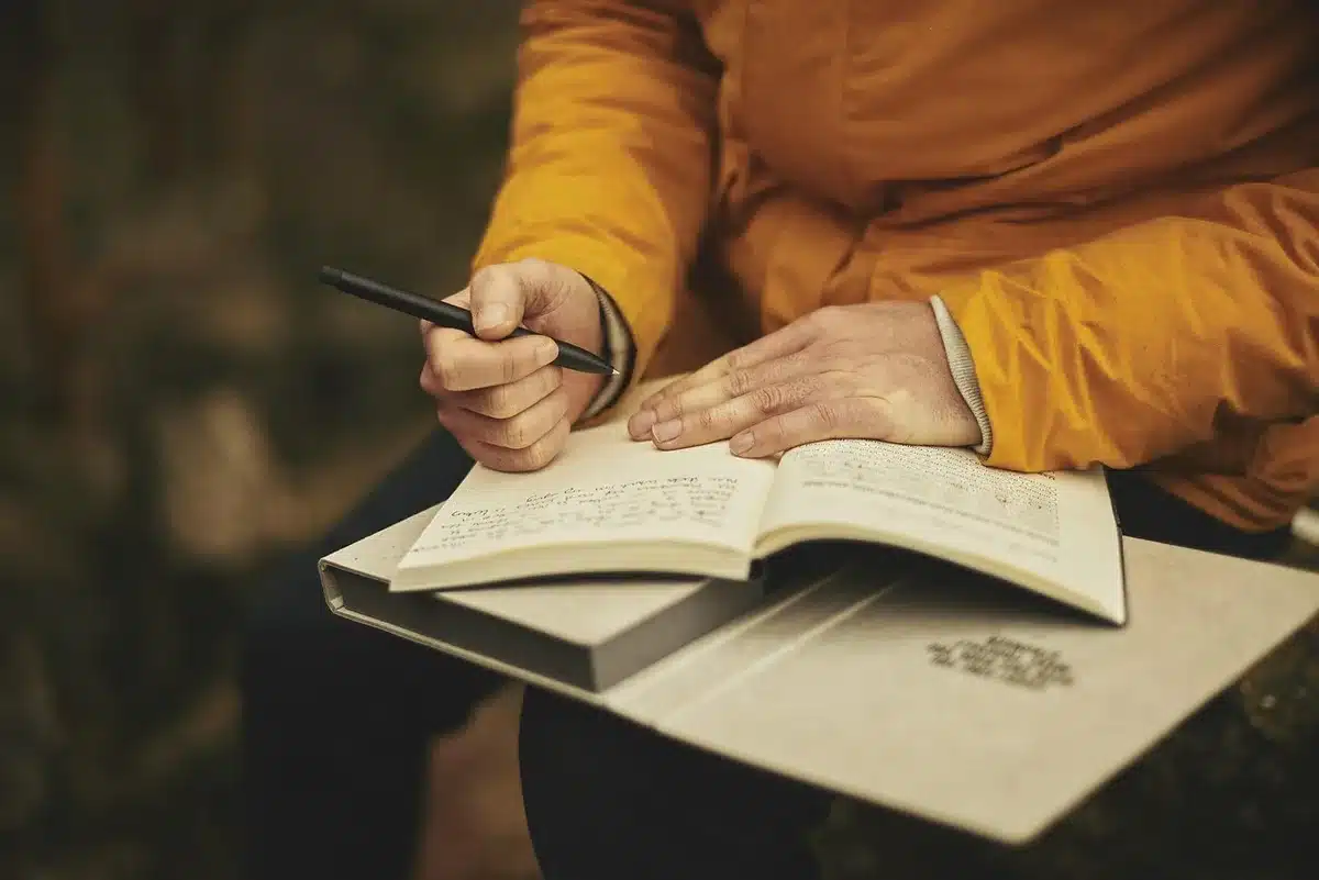 Personne comparant deux devis d'assurance sur un ordinateur portable avec documents