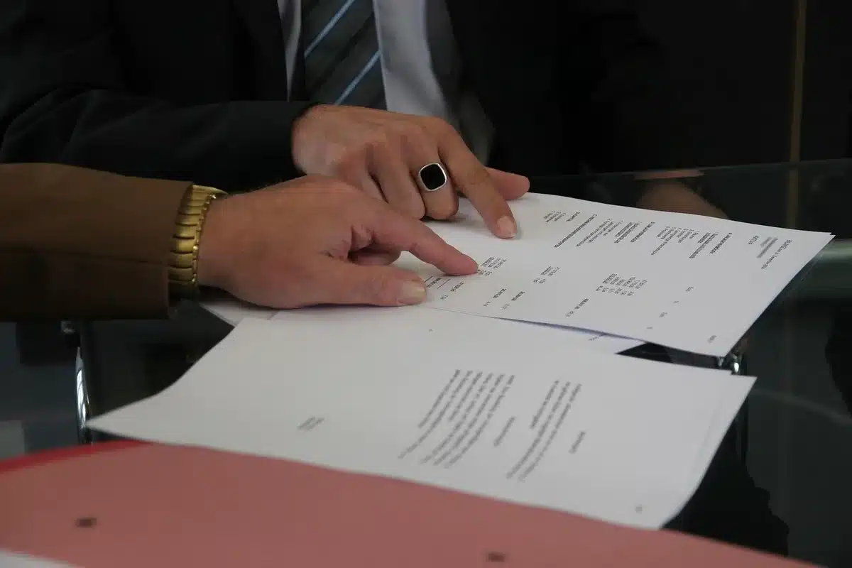 Documents, courriels et notes disposés sur un bureau lors d'une consultation juridique