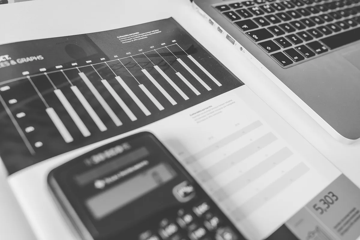 Documents financiers, calculatrice et notes pour comparer frais et caractéristiques d'un ETF