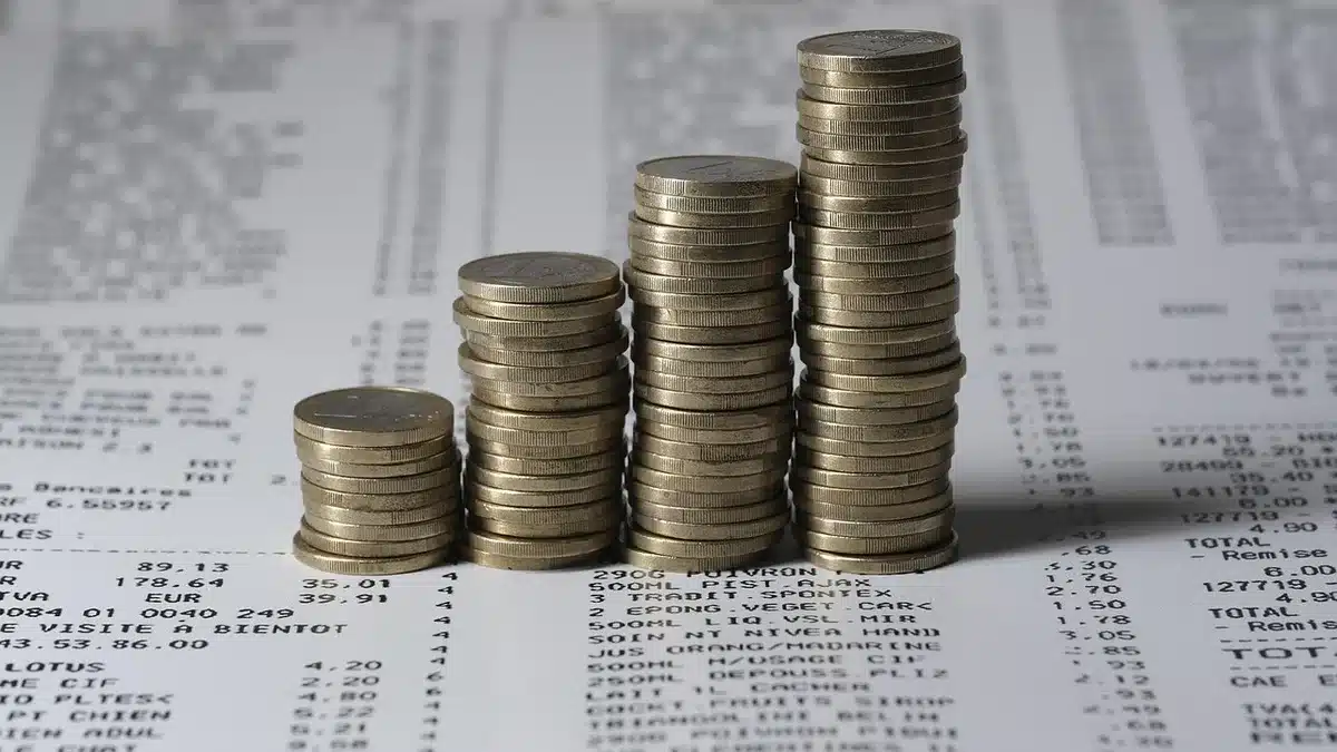 Main notant une répartition d'actifs sur des papiers financiers avec une calculatrice