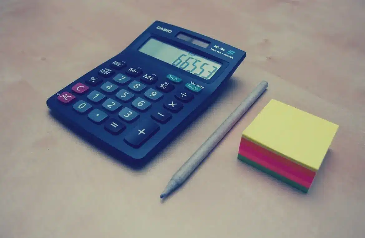 Bureau lumineux avec ordinateur, fiche d'obligations et calculatrice sur une table