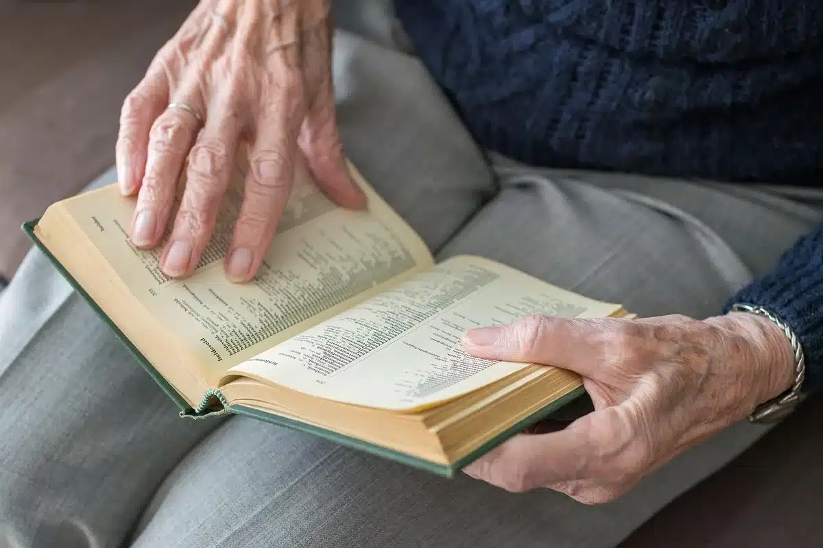 Intervenant assis à une table avec une personne âgée dans une pièce éclairée