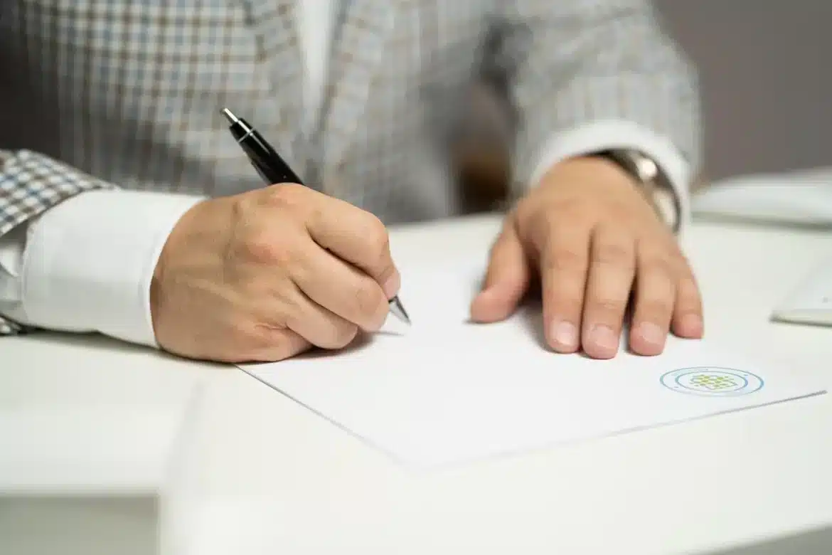 Table de bureau en journée avec documents financiers, calculatrice et mains anonymes