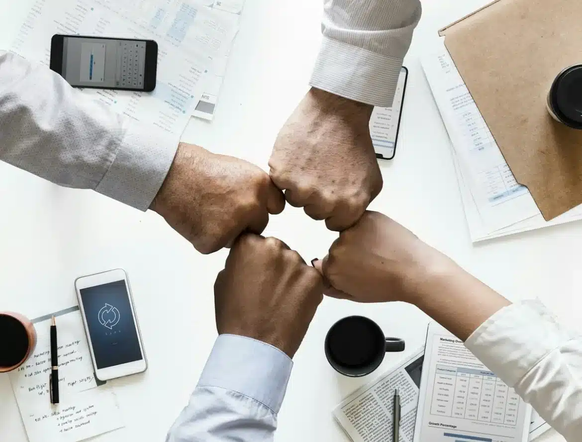 Bureau lumineux avec contrat imprimé et mains anonymes désignant des clauses