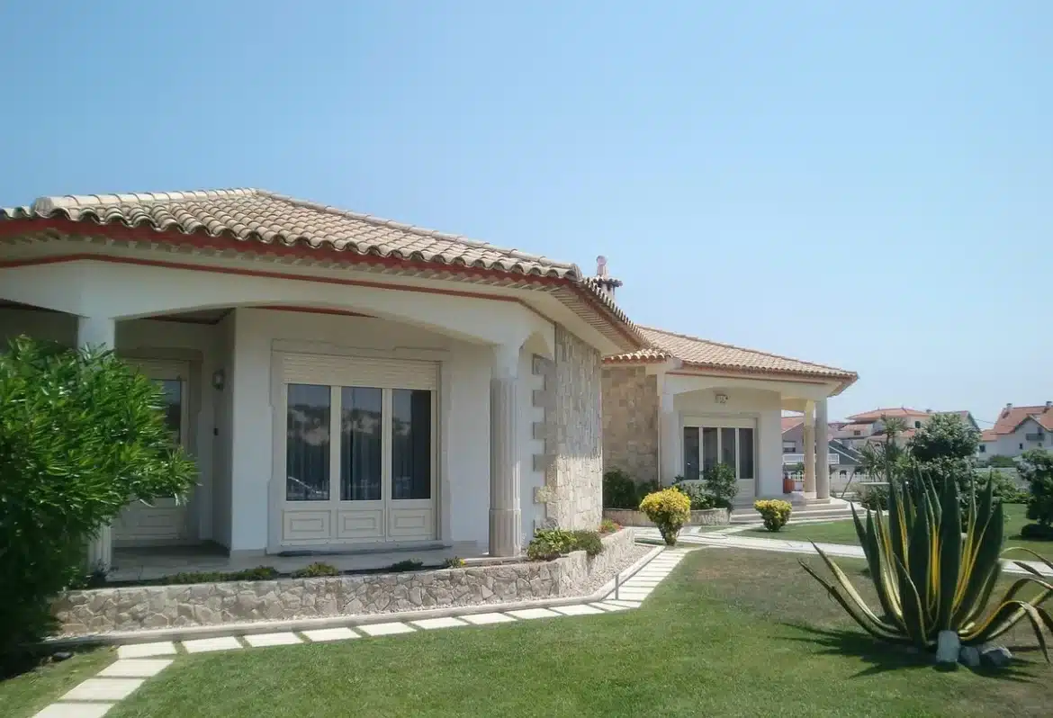 Rue ensoleillée à Montecito avec une villa privée et jardin, évoquant confidentialité et accès aux cercles influents