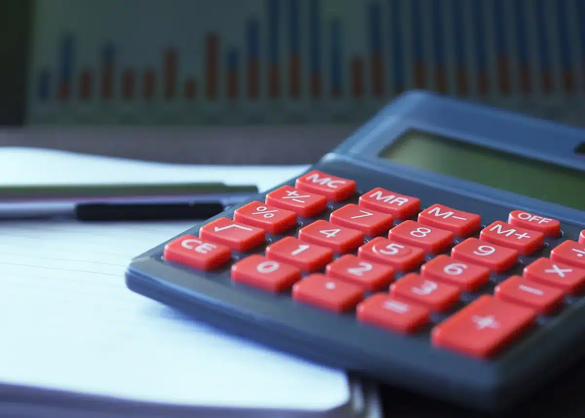 Calculatrice et fiches de paie sur un bureau pour estimer le salaire journalier de référence
